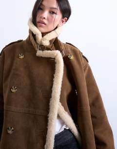 Model wearing Longline aviator shearling in tan cream in tan and cream