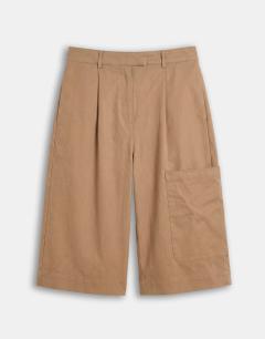 Model wearing Longline bermuda cargo short in ecru