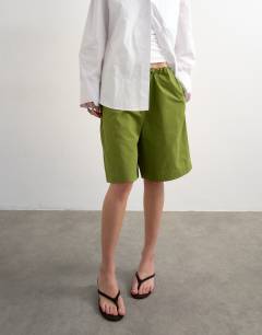 Model wearing Longline cargo short with bungee cords in green