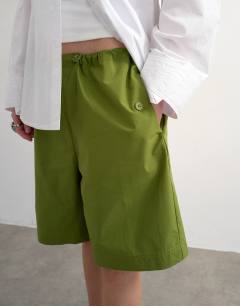 Model wearing Longline cargo short with bungee cords in green