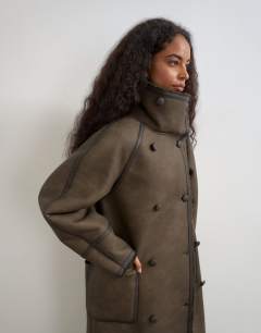Model wearing Longline faux leather funnel neck coat in brown