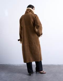 Model wearing Longline funnel aviator shearling in tan and cream