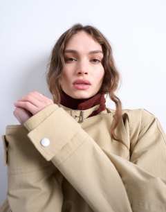 Model wearing Longline oversized funnel trench coat with contrast collar and buckle detail in beige