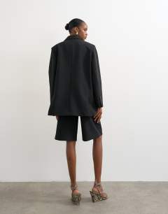 Model wearing Longline tailored bermuda short in black
