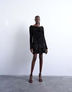 Model wearing Longsleeve cowl back mini sequin velvet dress in black
