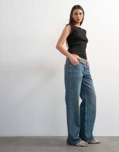 Model wearing Low rise belted jean in mid blue