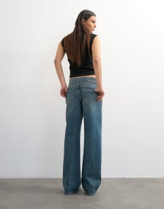 Model wearing Low rise belted jean in mid blue