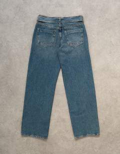 Model wearing Low rise belted jean in mid blue