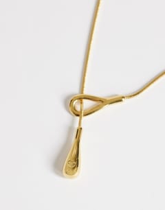 Model wearing Lucas waterproof teardrop lariat necklace in stainless gold