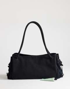 Model wearing Maisie large shoulder bag with real leather tassels in black