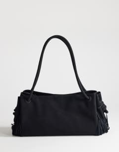 Model wearing Maisie large shoulder bag with real leather tassels in black