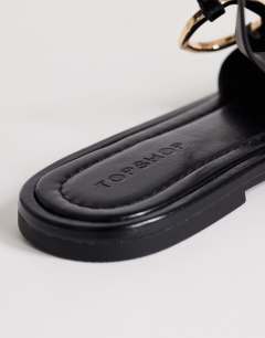Model wearing Mandy round toe flat sandal with hardware in black