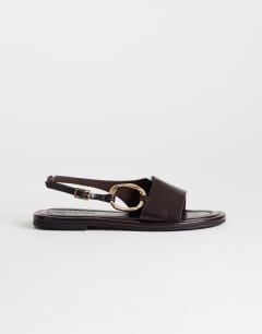 Model wearing Mandy round toe flat sandal with hardware in chocolate