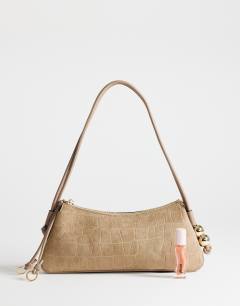 Model wearing Marley small croc suede shoulder bag in taupe