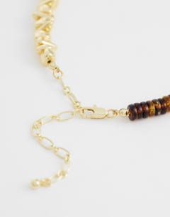 Model wearing Mateo beaded necklace in gold and orange