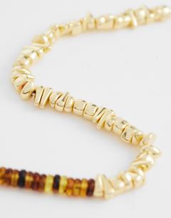Model wearing Mateo beaded necklace in gold and orange
