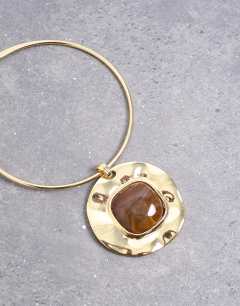Model wearing Max statement necklace in gold with brown stone