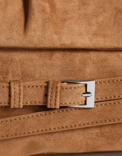 Model wearing Meadow oversized strap clutch in tan