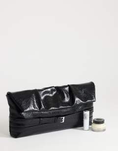 Model wearing Meadow strap clutch in black faux suede