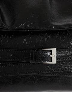 Model wearing Meadow strap clutch in black faux suede