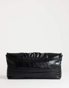 Model wearing Meadow strap clutch in black faux suede