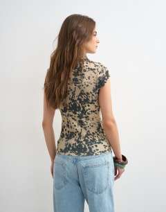 Model wearing Mesh animal cap sleeve top in cow print