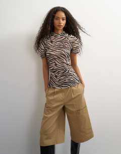 Model wearing Mesh ruched sleeve top in zebra print
