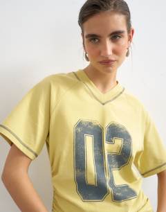 Model wearing Micro v-neck ruched side graphic tee in yellow
