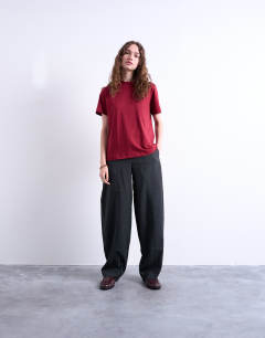 Model wearing Mid rise balloon leg clean waistband tapered trouser in charcoal