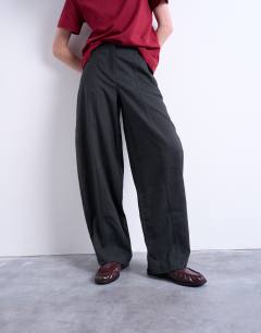 Model wearing Mid rise balloon leg clean waistband tapered trouser in charcoal