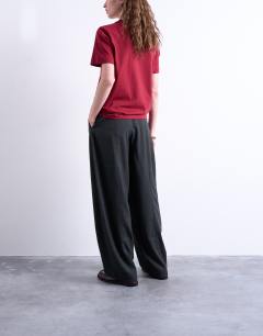 Model wearing Mid rise balloon leg clean waistband tapered trouser in charcoal