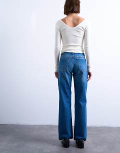 Model wearing Mid rise bootcut jean in vintage blue