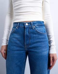 Model wearing Mid rise bootcut jean in vintage blue