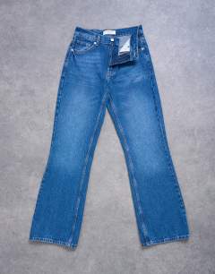 Model wearing Mid rise bootcut jean in vintage blue