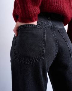 Model wearing Mid rise bootcut jean in washed black