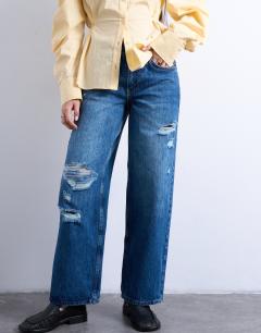 Model wearing Mid rise cinch jean with knee rip in vintage blue