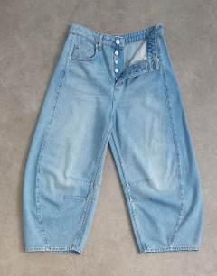 Model wearing Mid rise crop barrel jean in bleach