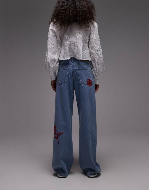 Topshop mid rise loose fit jeans with red floral embroidery in mid blue