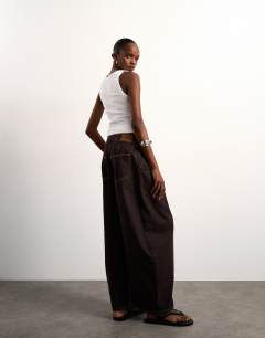 Model wearing Mid rise oversized belted barrel jean in chocolate