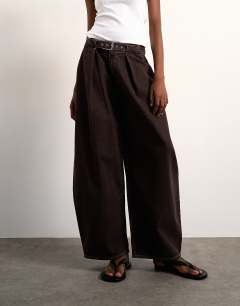 Model wearing Mid rise oversized belted barrel jean in chocolate