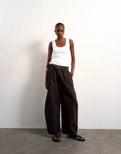 Model wearing Mid rise oversized belted barrel jean in chocolate