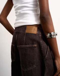 Model wearing Mid rise oversized belted barrel jean in chocolate