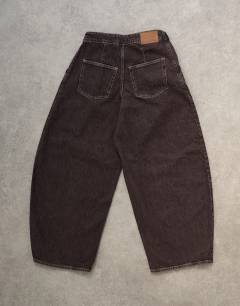 Model wearing Mid rise oversized belted barrel jean in chocolate
