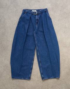 Model wearing Mid rise oversized belted barrel jean in rich indigo