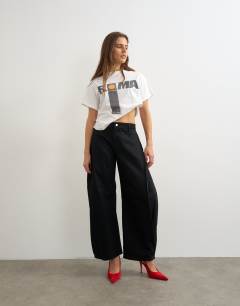 Model wearing Mid rise Side pleat balloon jean in clean black