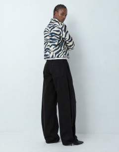 Model wearing Mid rise Side pleat balloon jean in clean black