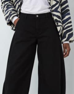 Model wearing Mid rise Side pleat balloon jean in clean black