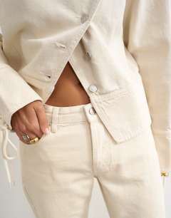 Model wearing Mid rise straight leg jean with lace up detail in oat
