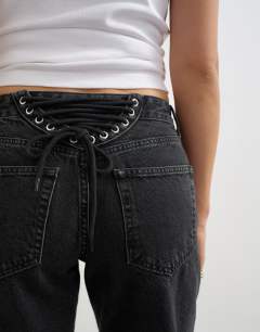 Model wearing Mid rise straight leg jean with lace up detail in washed black