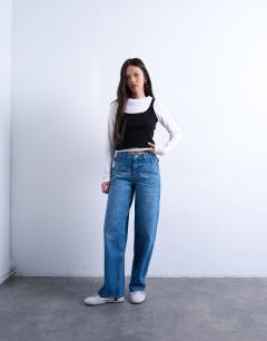 Model wearing Mid rise yoke front cinch jean in mid blue